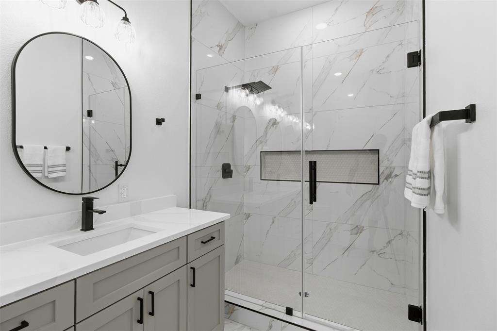 429 Waterboard Road Trinidad, TX 75163 - Photo 19 of 25 Contemporary bathroom featuring a spacious glass-enclosed shower with large format tile, a built-in shower niche, and matte black fixtures