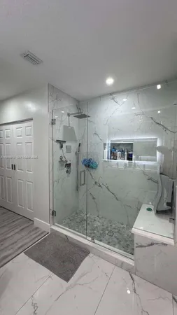 a bathroom with a shower a mirror and a shower