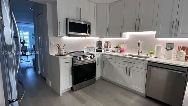 a kitchen with stainless steel appliances a stove a sink and a microwave