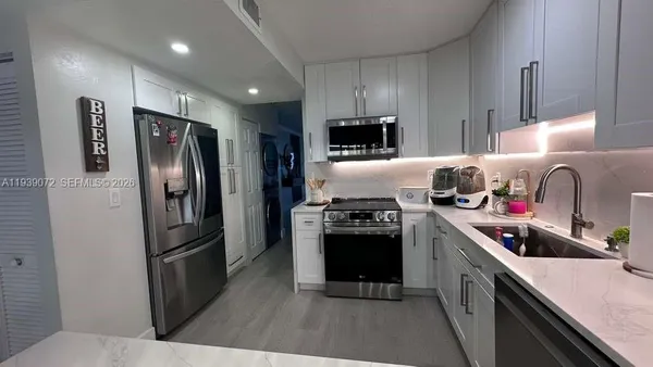 a kitchen with stainless steel appliances granite countertop a refrigerator stove microwave and sink