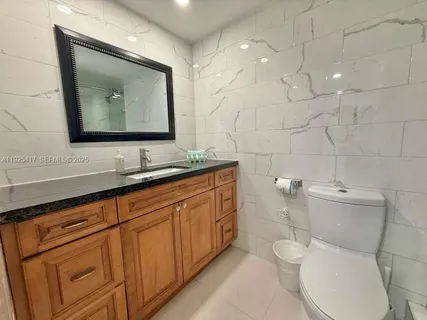 a bathroom with a toilet sink and mirror