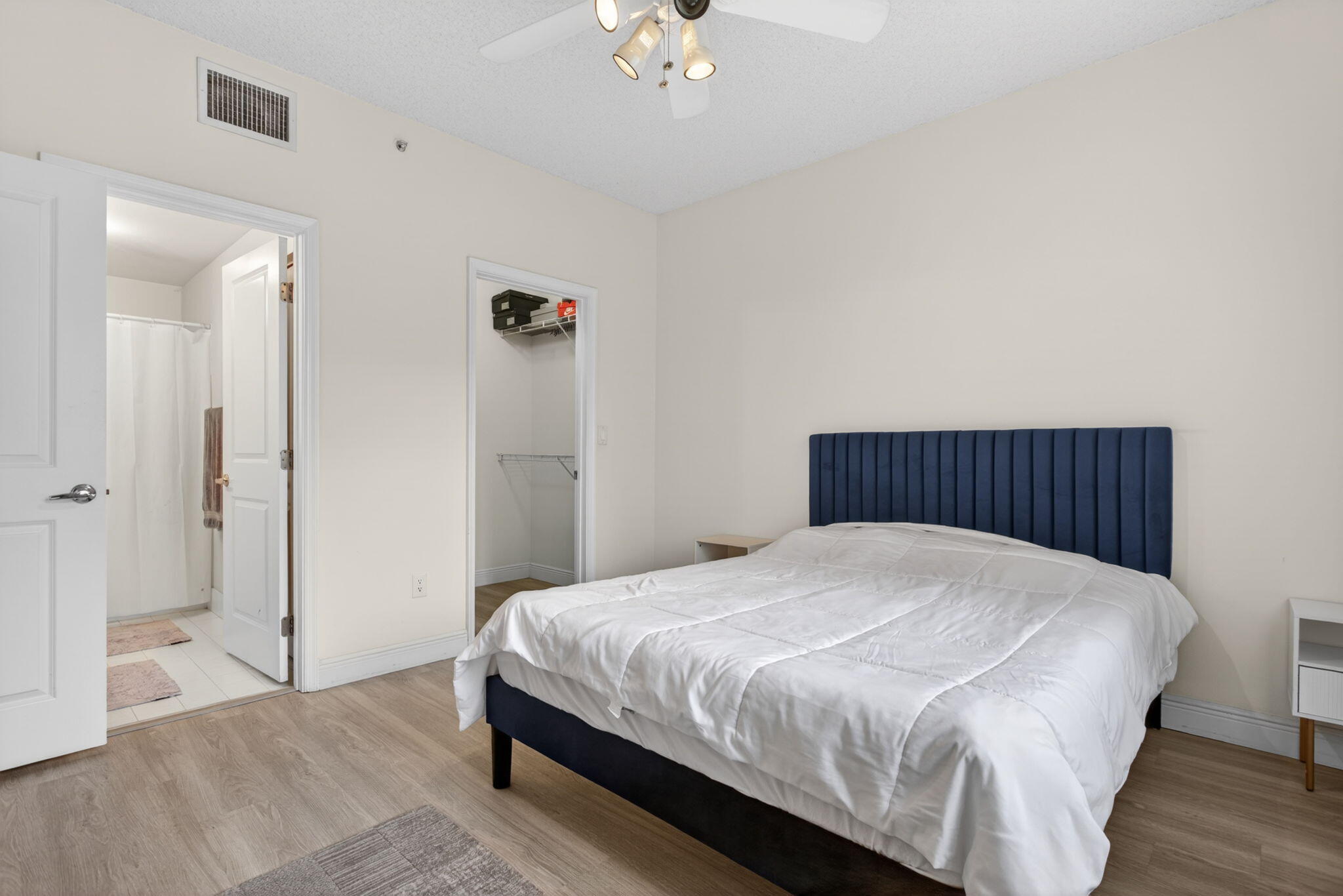 5880 West Sample Road, Unit 206 Coral Springs, FL 33067 - Photo 26 of 37 a bedroom with a bed and a chandelier