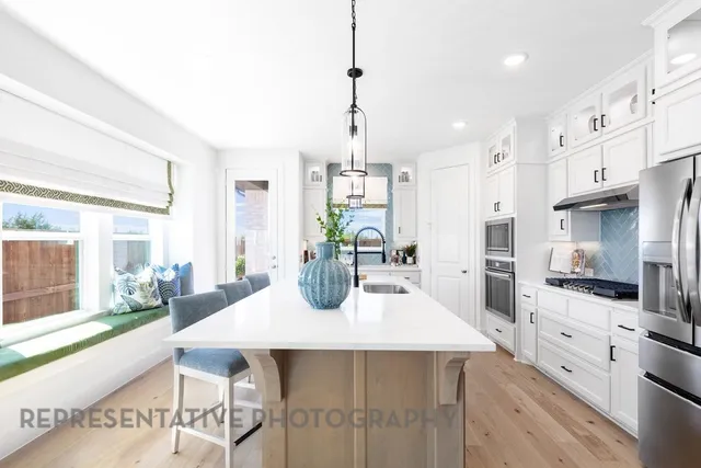 a kitchen with a table chairs refrigerator and microwave