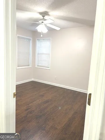 a view of an empty room with windows and a chandelier