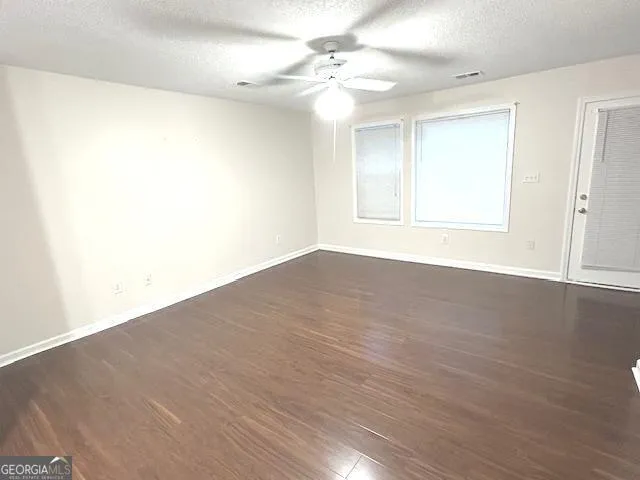 a view of a hallway to a livingroom with wooden floor and stairs