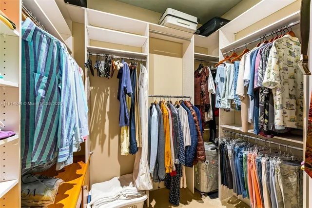 a view of walk in closet with clothes