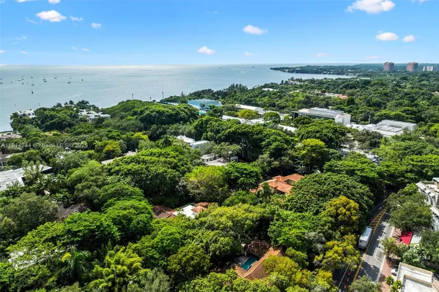 an aerial view of residential houses with outdoor space and trees