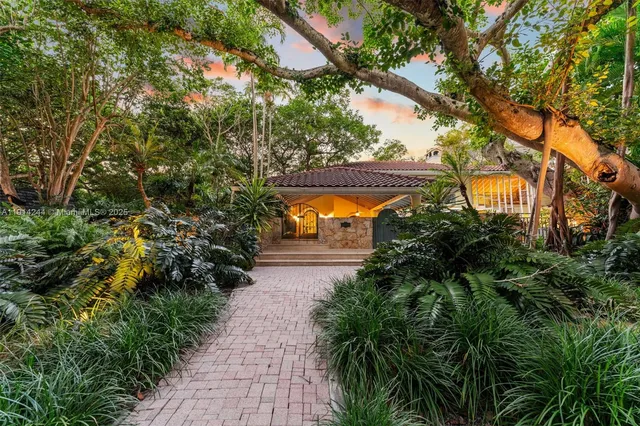 a view of a house with a tree and plants
