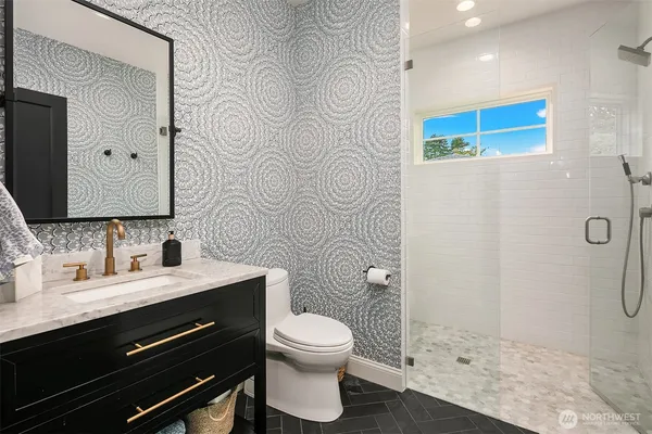 a bathroom with a sink a toilet and shower