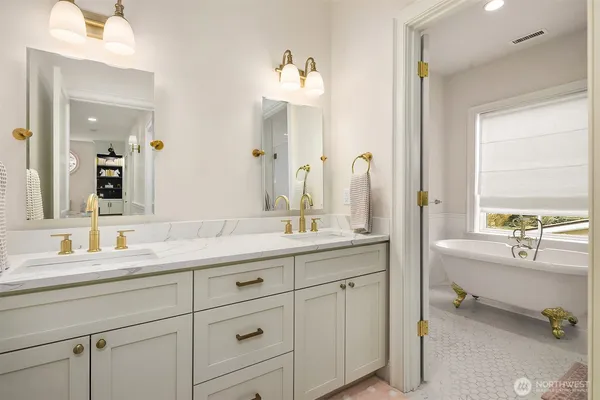 a bathroom with a granite countertop sink double vanity next to a window