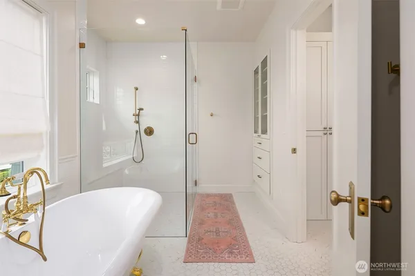 a bathroom with a tub shower sink and a mirror