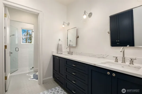 a bathroom with a double vanity sink toilet and shower