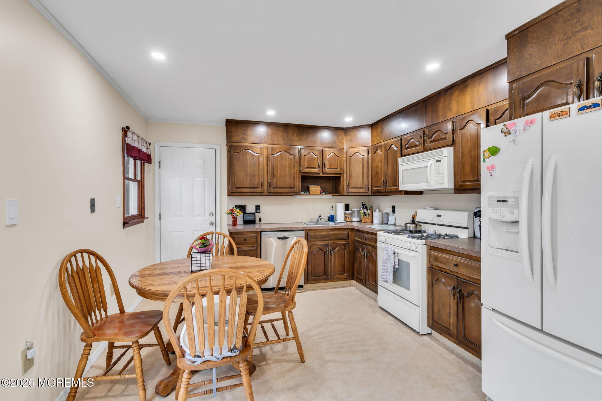 28 Oregon Avenue Jackson, NJ 08527 - Photo 9 of 33 a kitchen with stainless steel appliances granite countertop a dining table chairs refrigerator and microwave