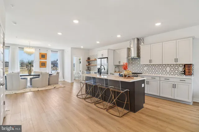 a dining room with wooden floor and large windows