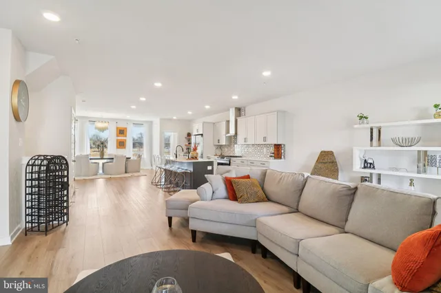 a living room with furniture a wooden floor and a large window