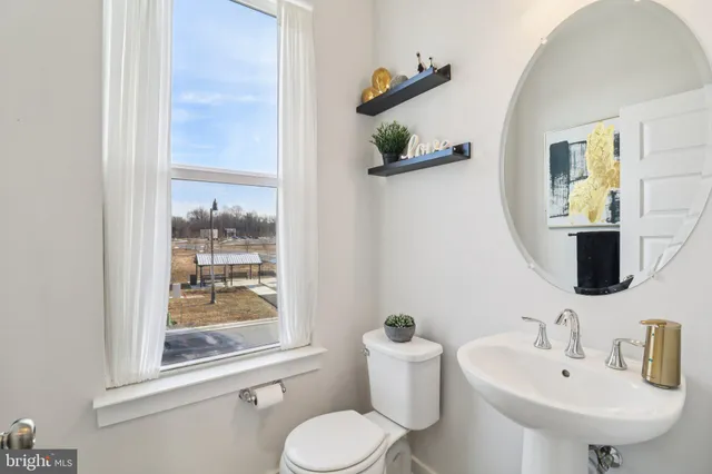 a spacious bedroom with a bed and dresser with wooden floor