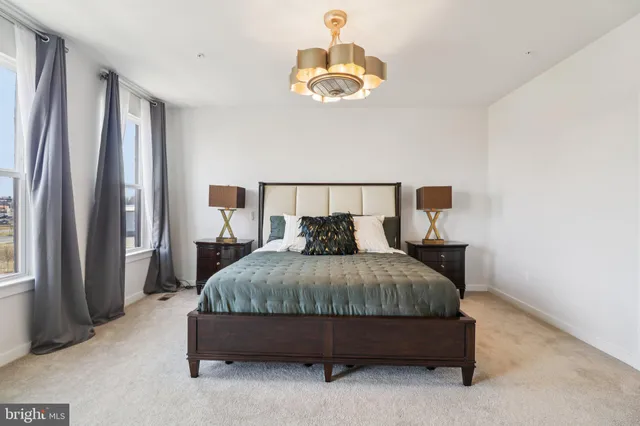 a bedroom with a bed and a lamp on dresser