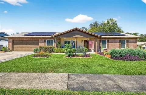 a front view of a house with a garden and yard