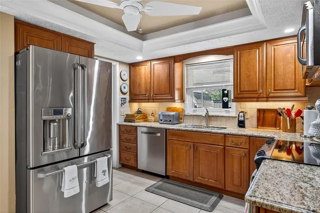 a kitchen with stainless steel appliances granite countertop a refrigerator and a sink