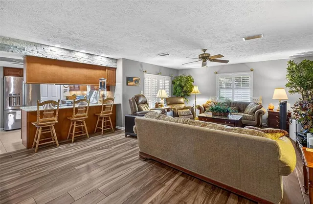 a living room with furniture a large window with kitchen view