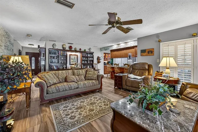 a living room with furniture kitchen view and a large window