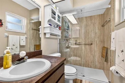 a bathroom with a granite countertop sink toilet and shower