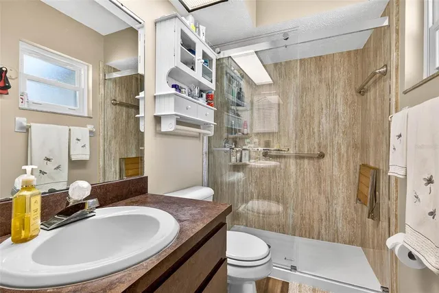 a bathroom with a granite countertop sink toilet and shower