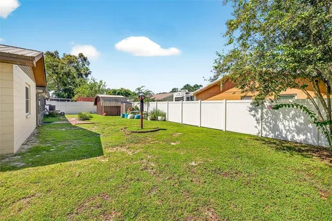 a view of a backyard with plants and a barbeque