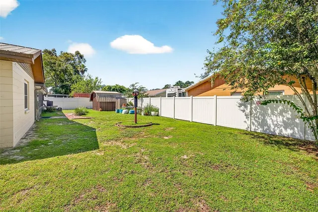 a view of a backyard with plants and a barbeque