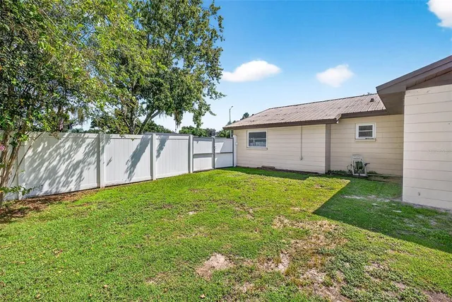 a view of a house with backyard and a tree