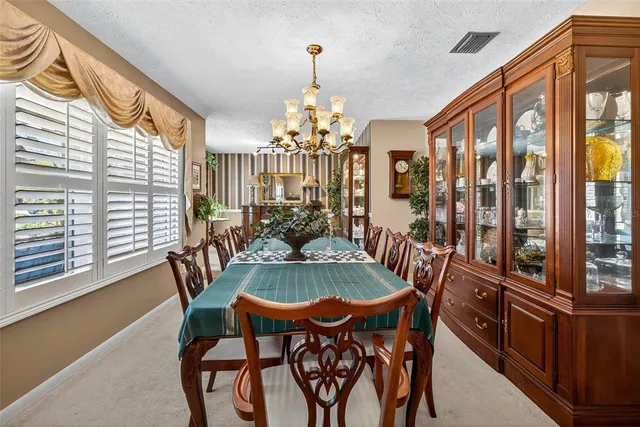 a dining room with furniture a chandelier and wooden floor