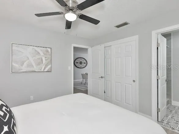a bedroom with a large bed and a chandelier