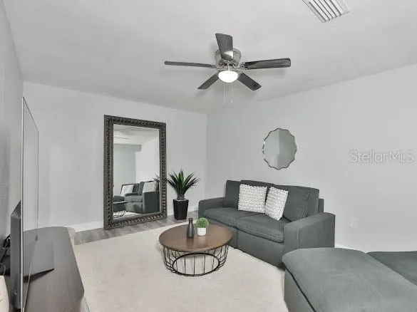 a living room with furniture potted plant and wooden floor