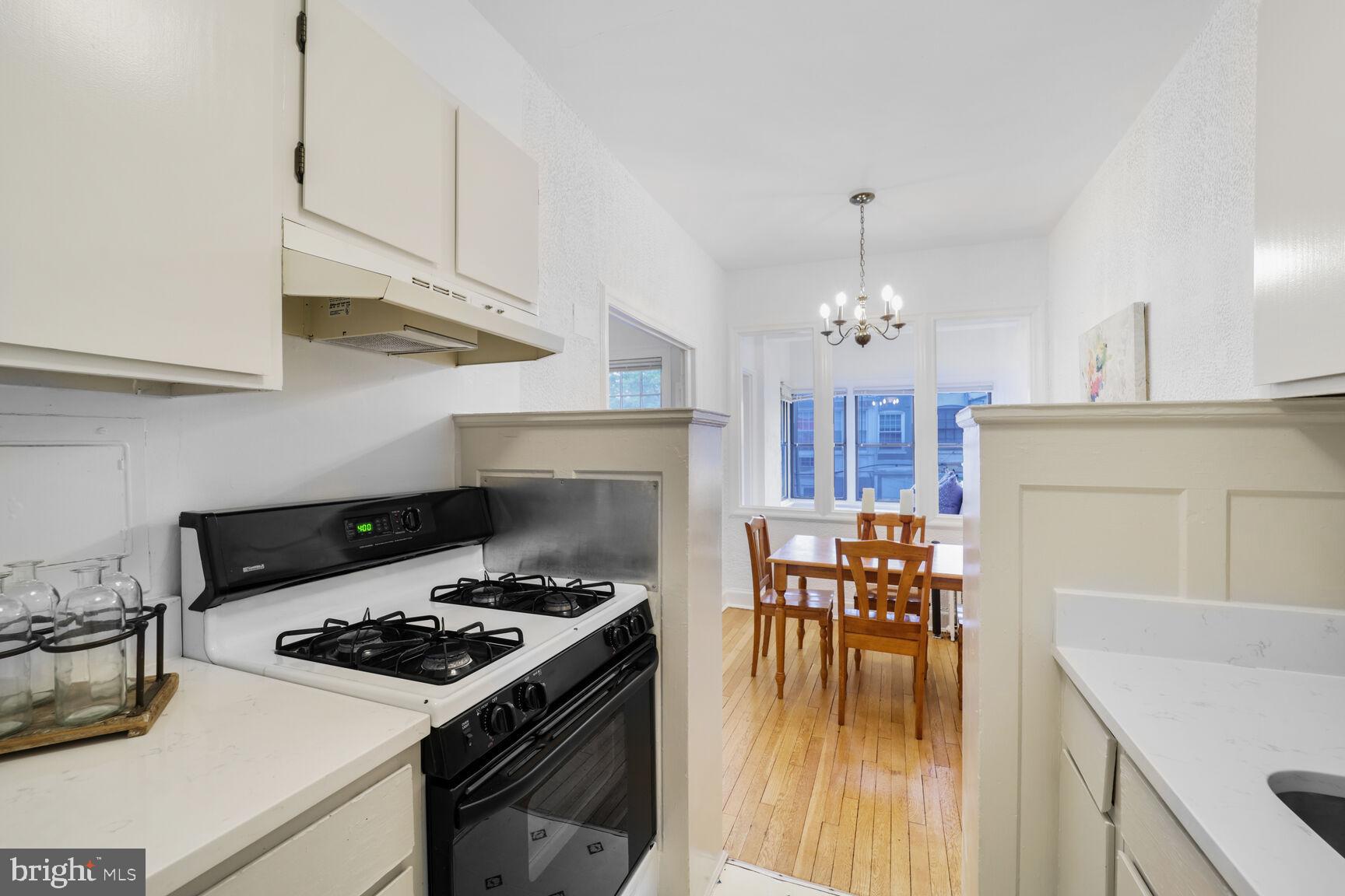 2032 Belmont Road Northwest, Unit 336 Washington, DC 20009 - Photo 12 of 23 a kitchen with a stove a sink and a refrigerator