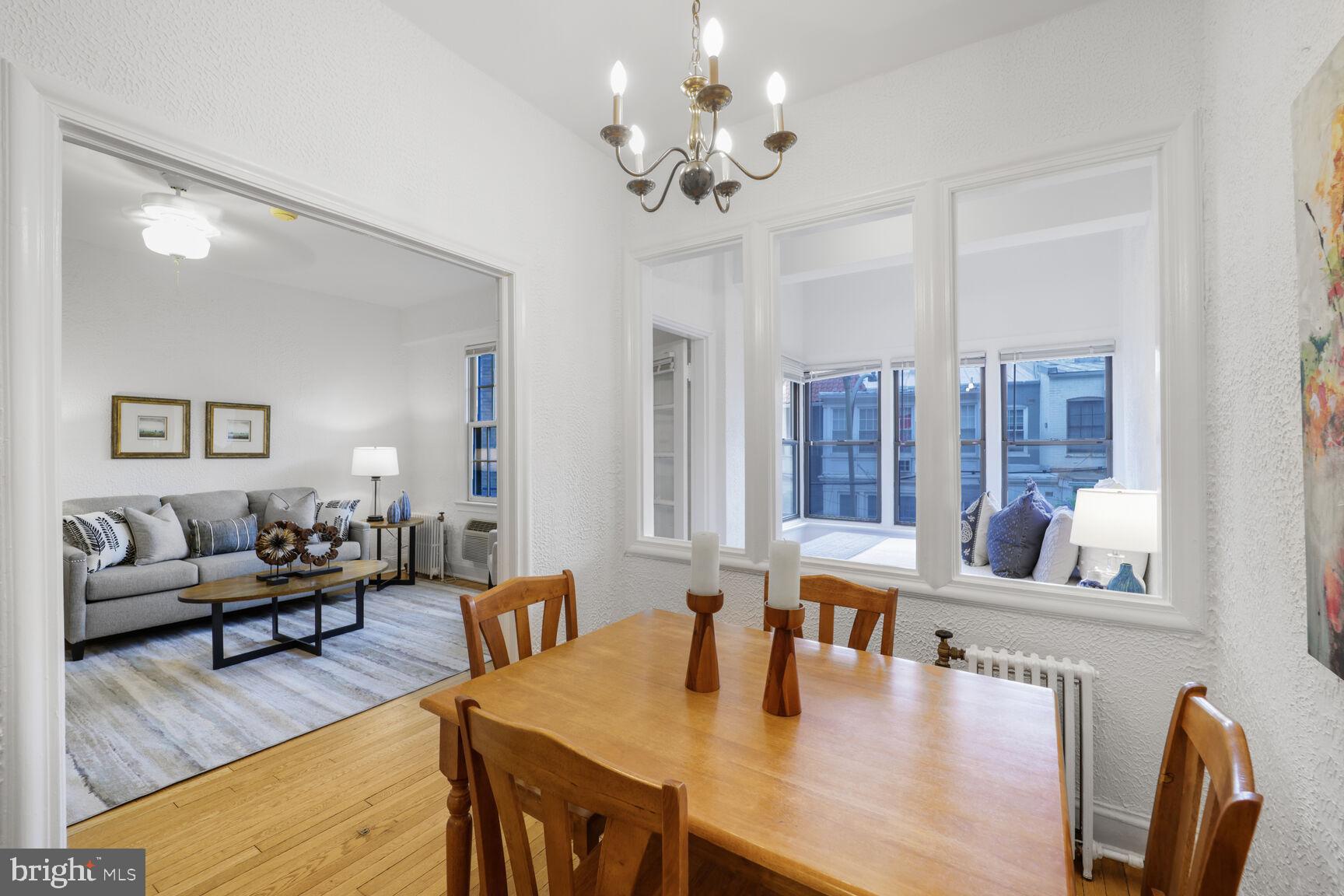 2032 Belmont Road Northwest, Unit 336 Washington, DC 20009 - Photo 14 of 23 a view of a dining room with furniture a chandelier and wooden floor