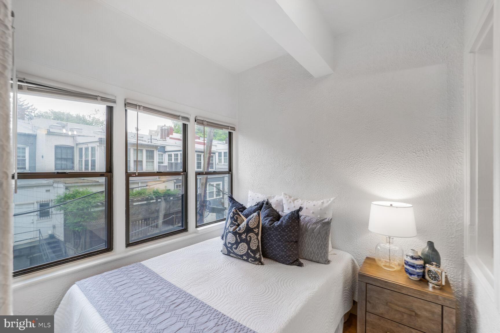 2032 Belmont Road Northwest, Unit 336 Washington, DC 20009 - Photo 15 of 23 a bedroom with a large bed and a balcony view