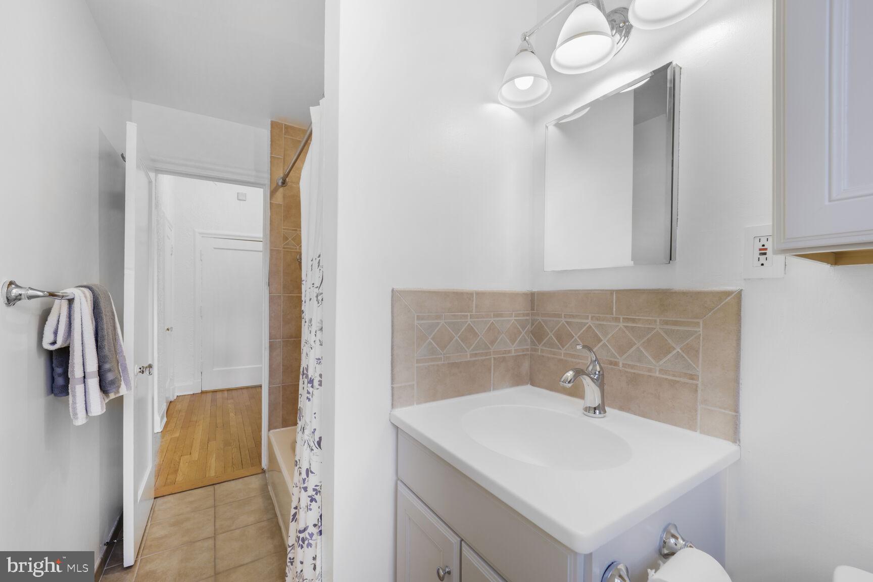 2032 Belmont Road Northwest, Unit 336 Washington, DC 20009 - Photo 20 of 23 a bathroom with a sink a toilet and mirror