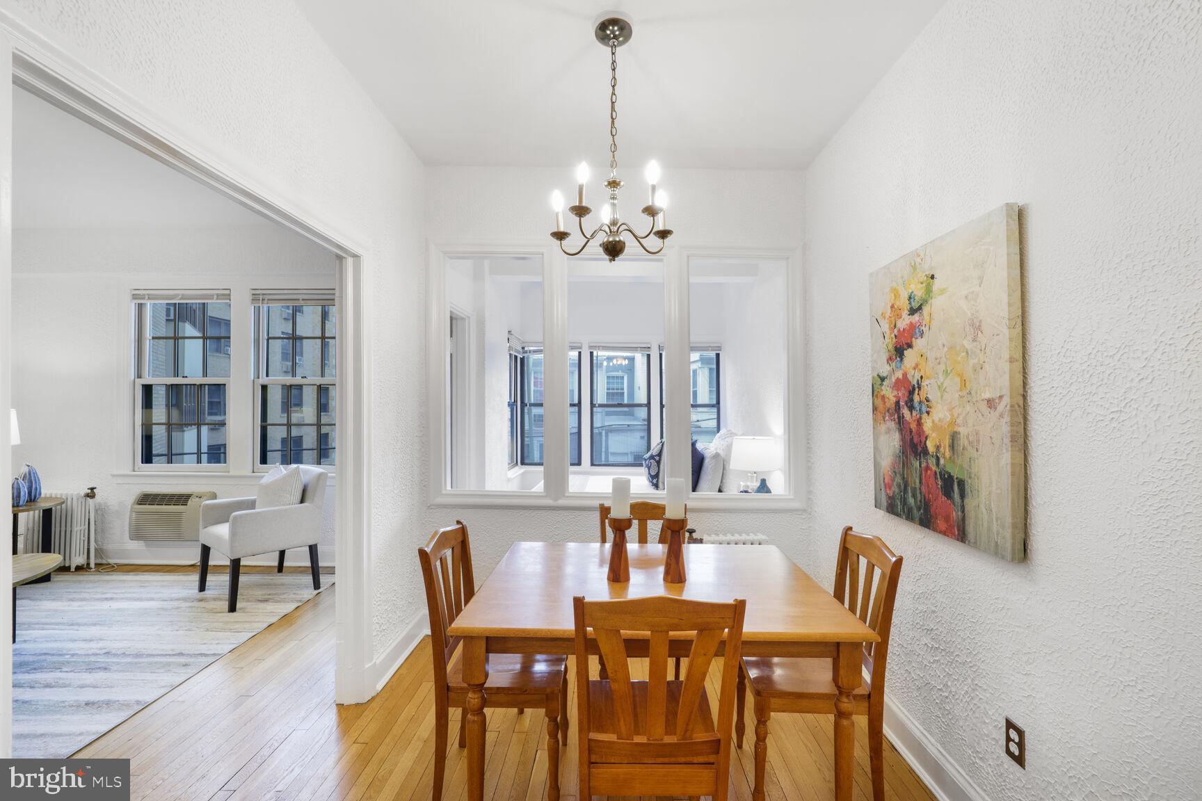 2032 Belmont Road Northwest, Unit 336 Washington, DC 20009 - Photo 9 of 23 a view of a dining room with furniture wooden floor and a chandelier