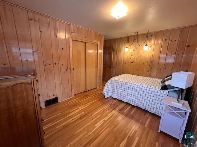 62 Elm Boulevard Babbitt, MN 55706 - Photo 12 of 21 Bedroom with visible vents, wooden walls, and wood finished floors
