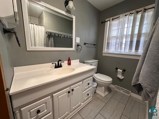 62 Elm Boulevard Babbitt, MN 55706 - Photo 14 of 21 Full bathroom with visible vents, curtained shower, baseboards, toilet, and vanity