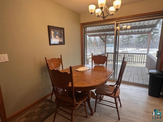 62 Elm Boulevard Babbitt, MN 55706 - Photo 4 of 21 Dining room with baseboards, light wood-style floors, and a chandelier
