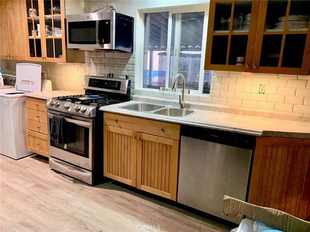 a kitchen with stainless steel appliances a stove sink and microwave