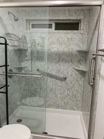 a bathroom with a toilet and a shower