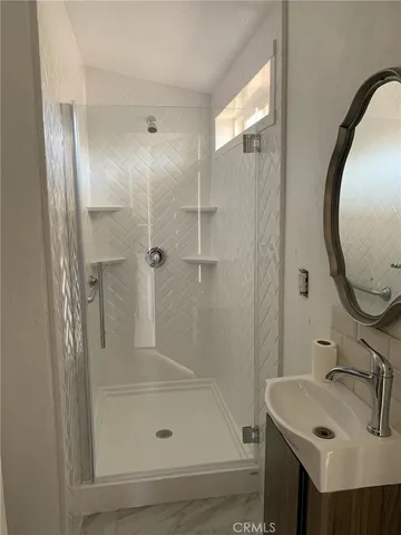 a bathroom with a sink and mirror with bathtub