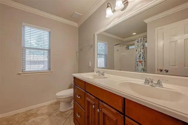 a bathroom with a sink double vanity and a toilet