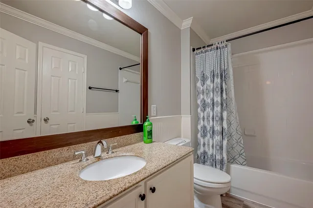 a bathroom with a granite countertop sink toilet a mirror a vanity and shower