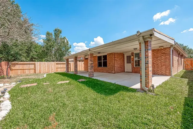 a view of a house with backyard and a tree