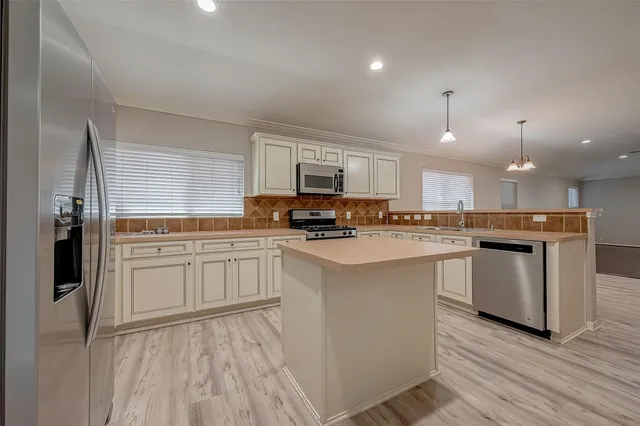 a kitchen with a refrigerator stove top oven and sink
