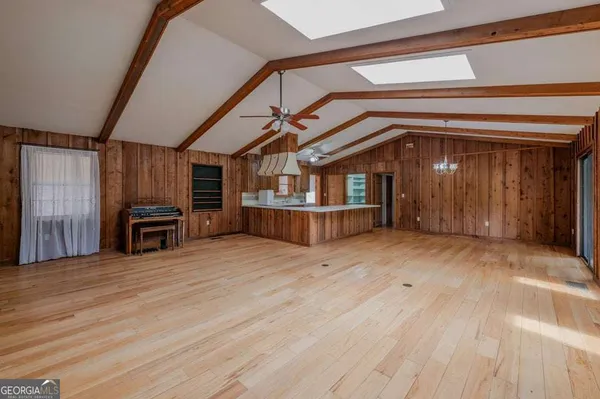 a view of a hallway with wooden floor and furniture