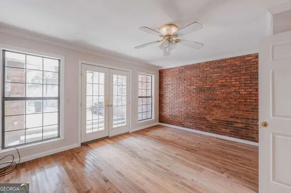 a view of an empty room with wooden floor and window